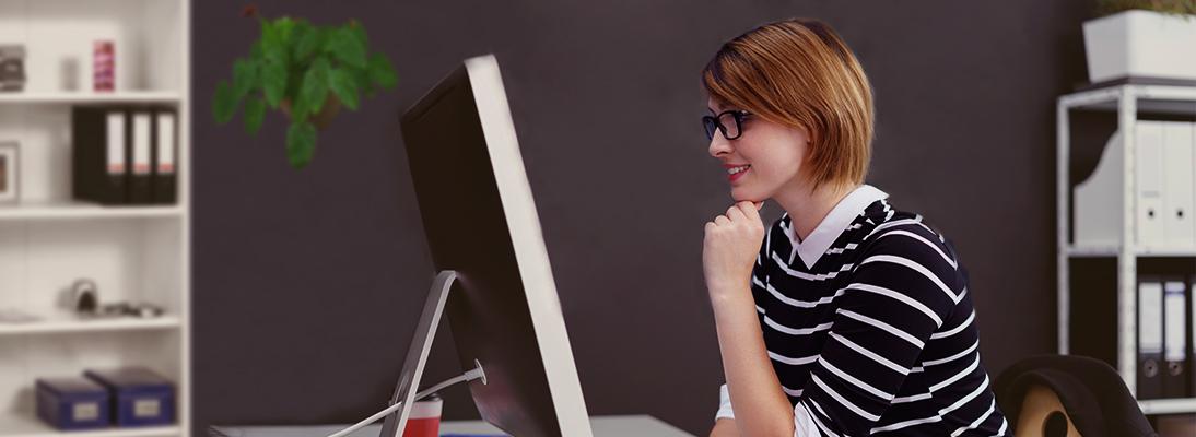 Young woman sitting in front of a screen with user interface by Libelle DataMasking